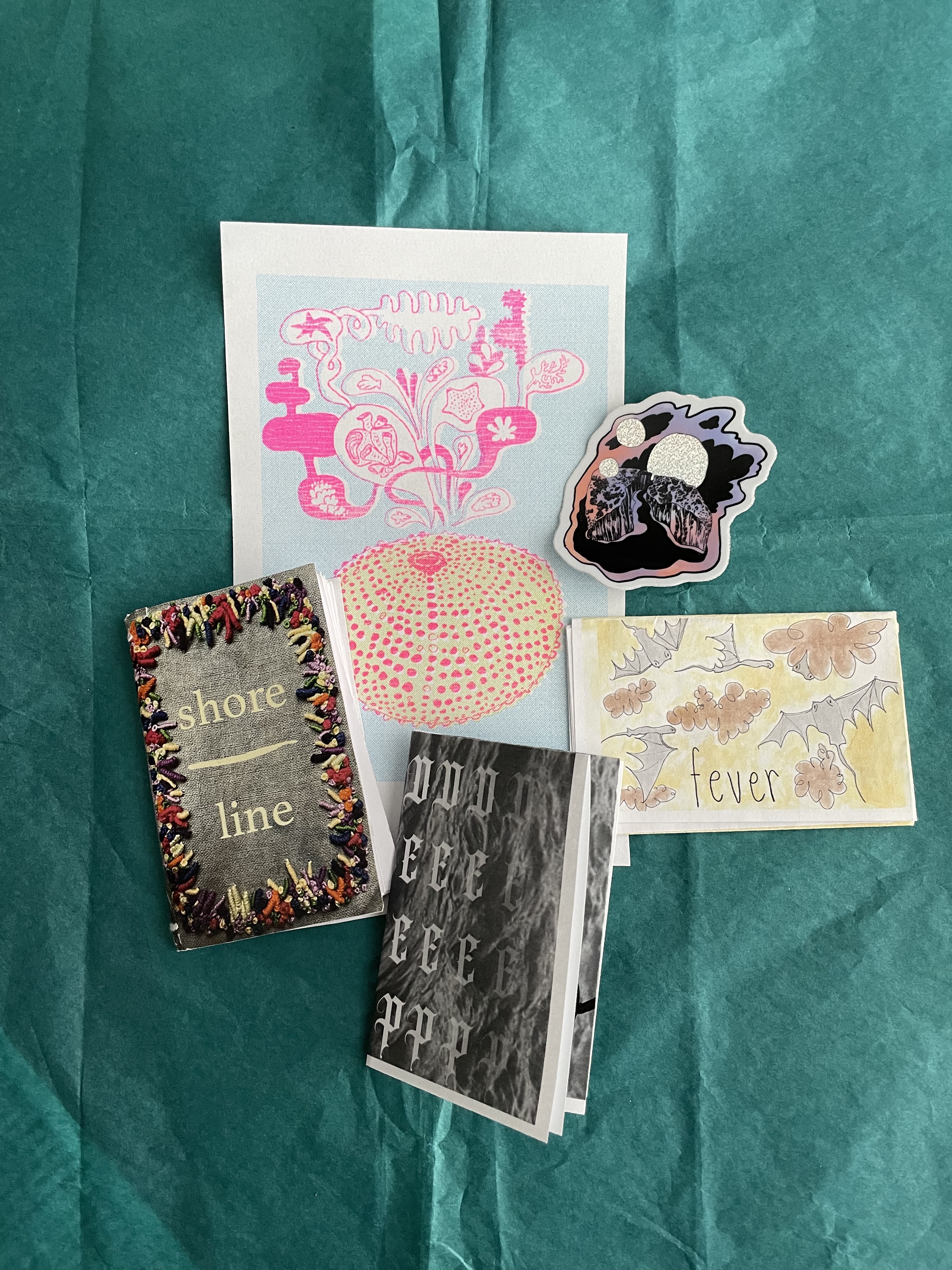 a collection of zines and artwork against a teal background