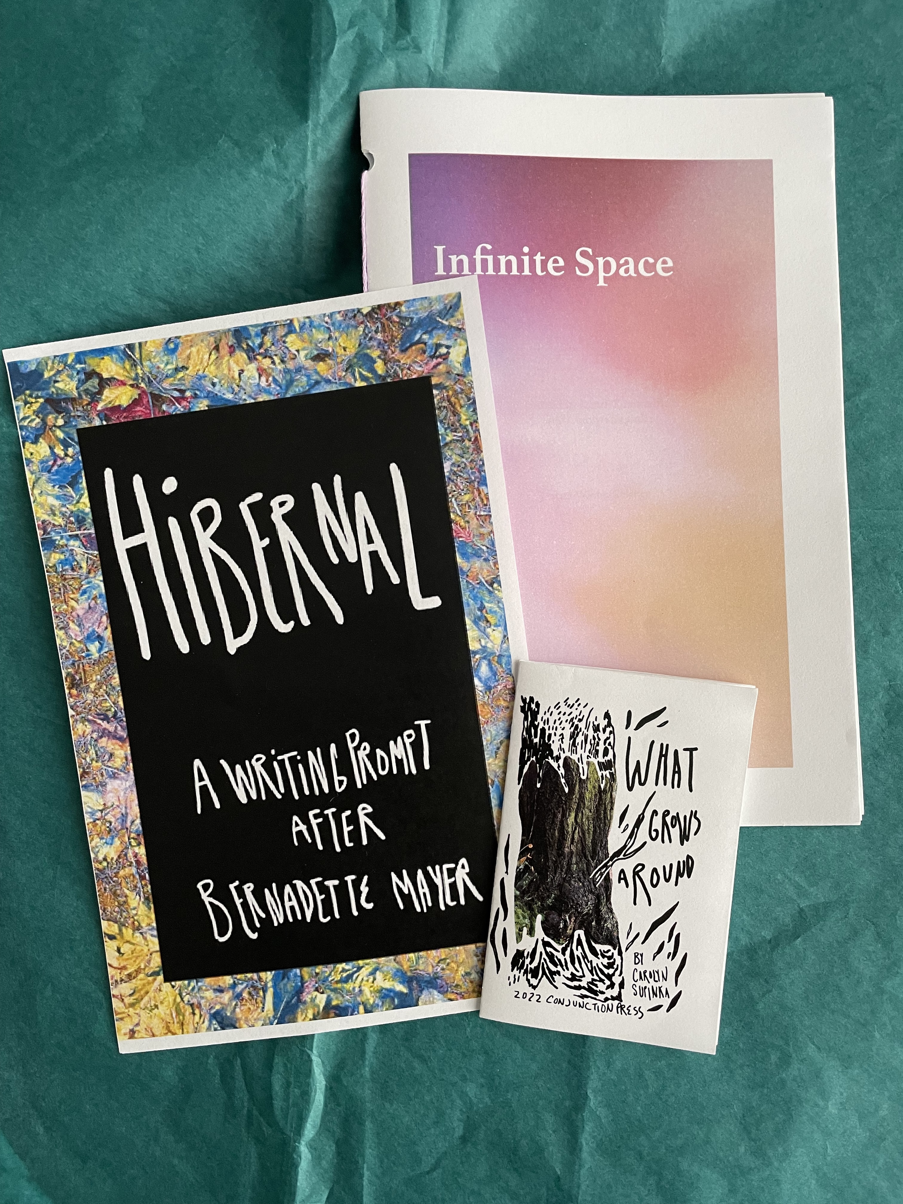 a collection of zines and artwork against a teal background